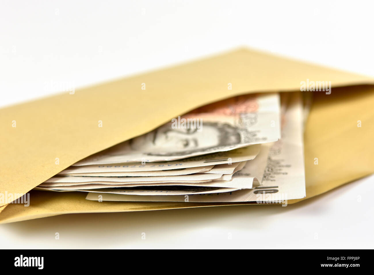 Wad of bank notes in British Sterling currency in brown envelope, mainly £10 notes Stock Photo