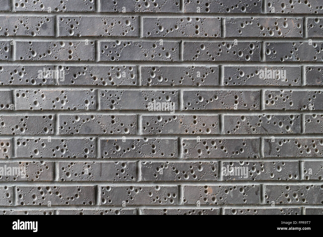 Modern bricks with decorative holes, grey wall background Stock Photo