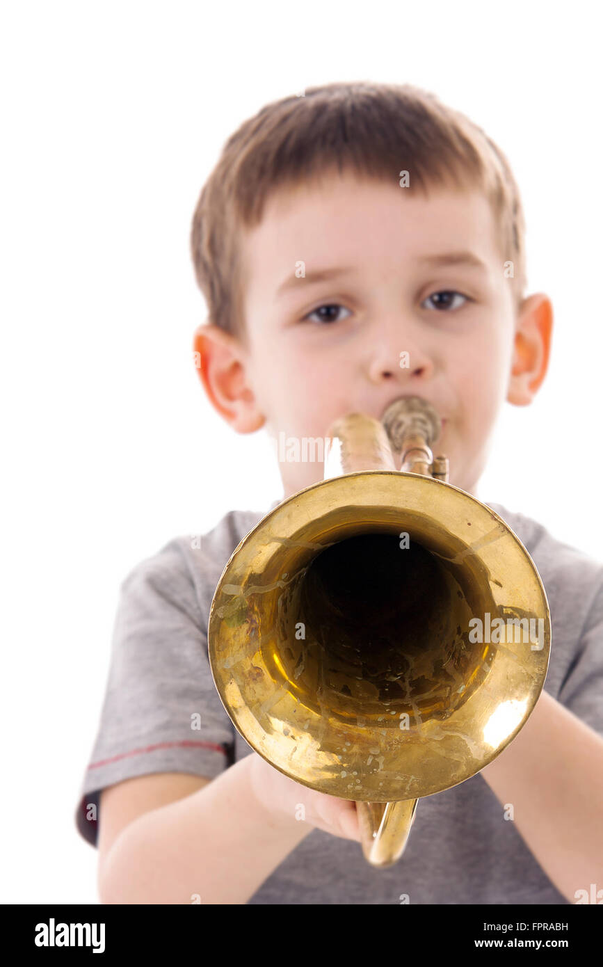 young boy blowing into a trumpet against white background Stock Photo