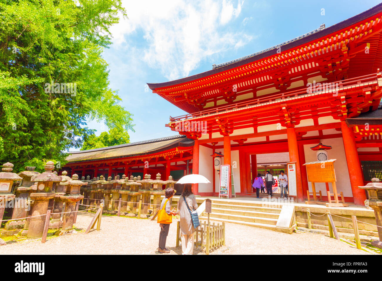 Japanese people at front red gate entrance to Kasuga-Taisha Shinto Shrine at the Todai-ji temple complex on a blue sky day. Hori Stock Photo