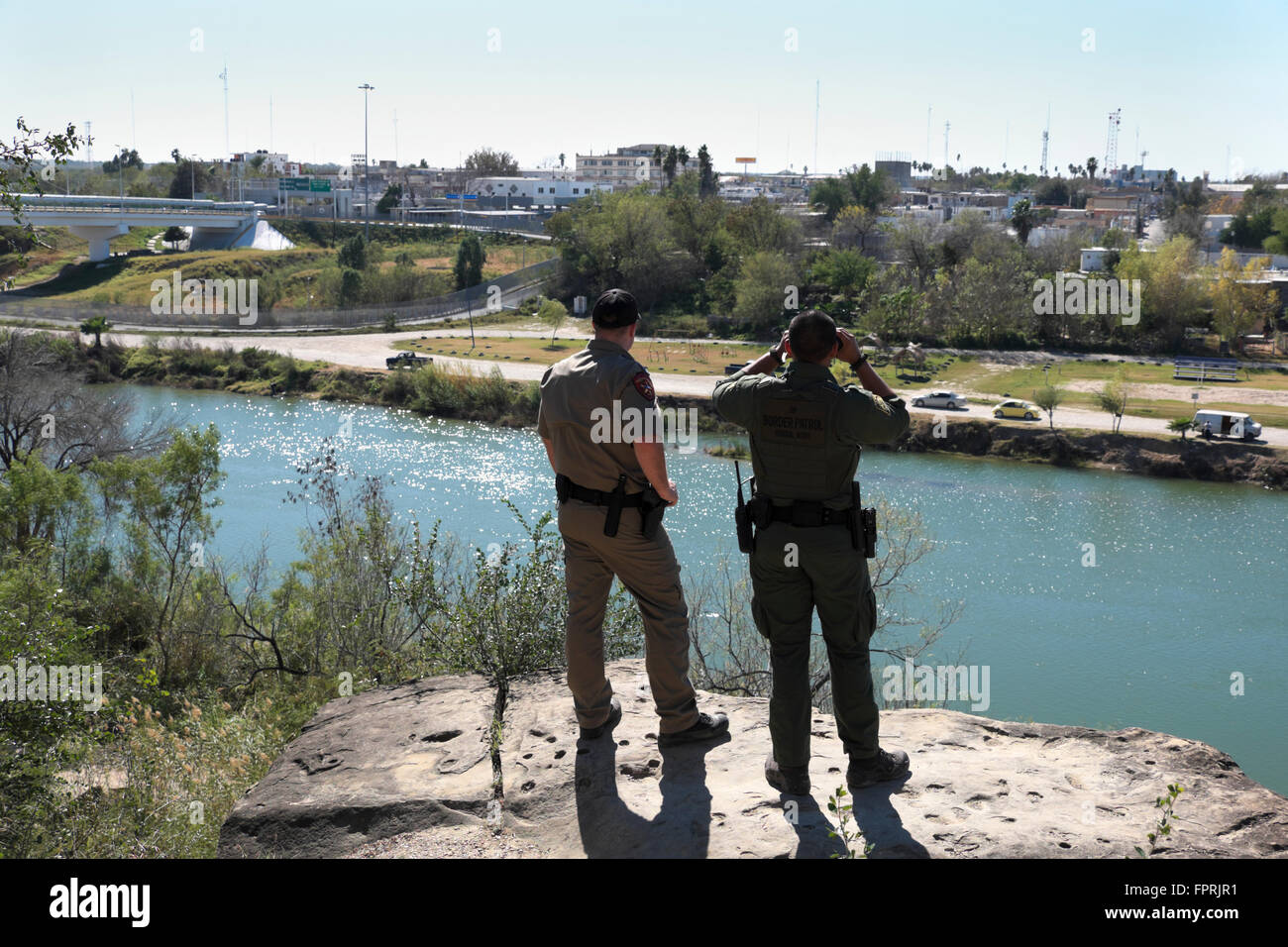 Border Patrol Agent and Texas Department of Public Safety officer observe activity in the city of Miguel Aleman. Stock Photo