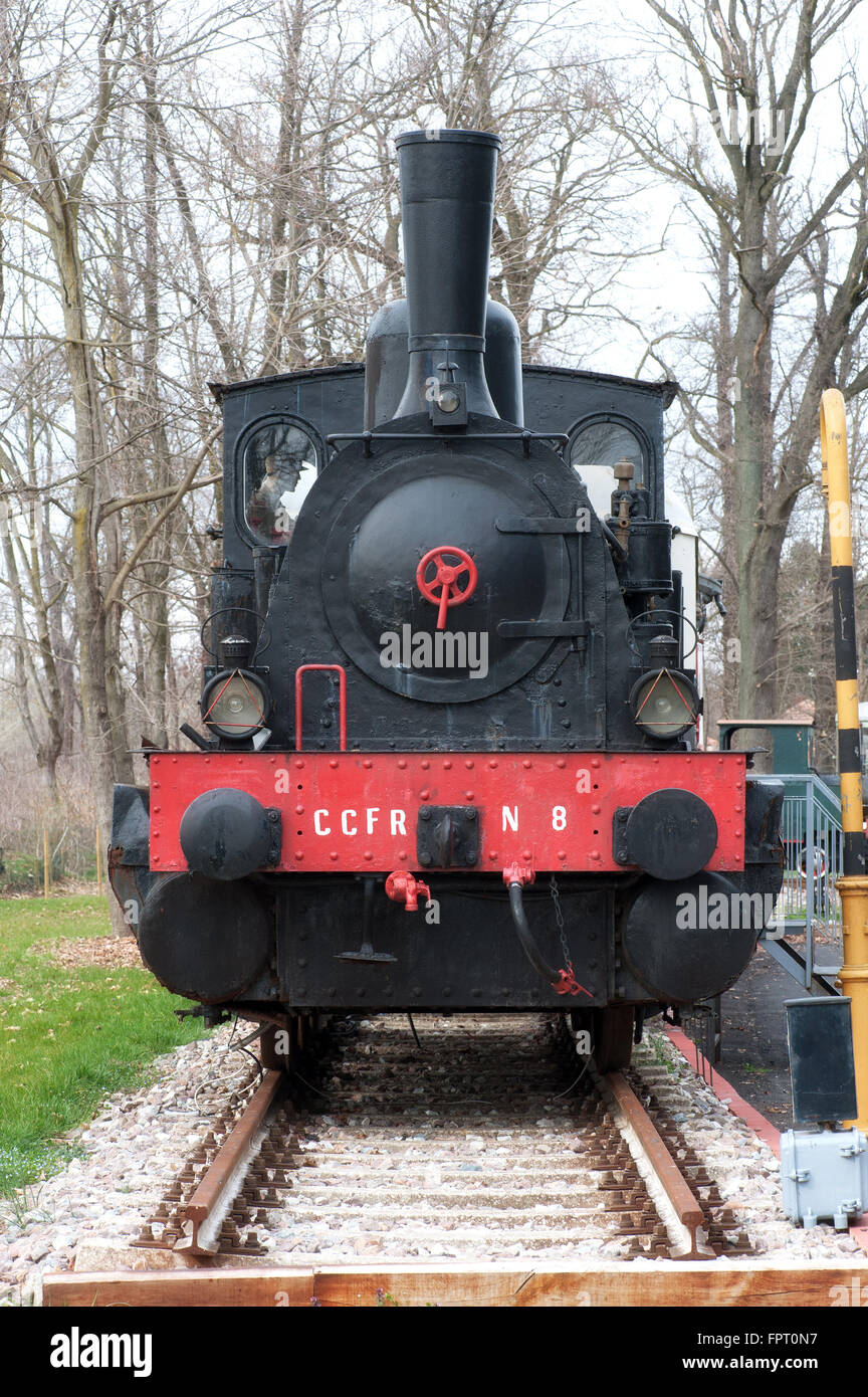 Front view on single old fashioned steam powered locomotive in outdoor museum display during winter Stock Photo