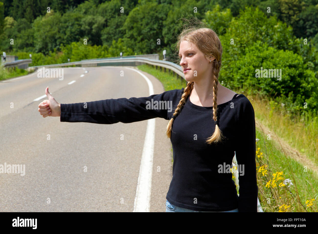 Young woman hitchhiking Stock Photo