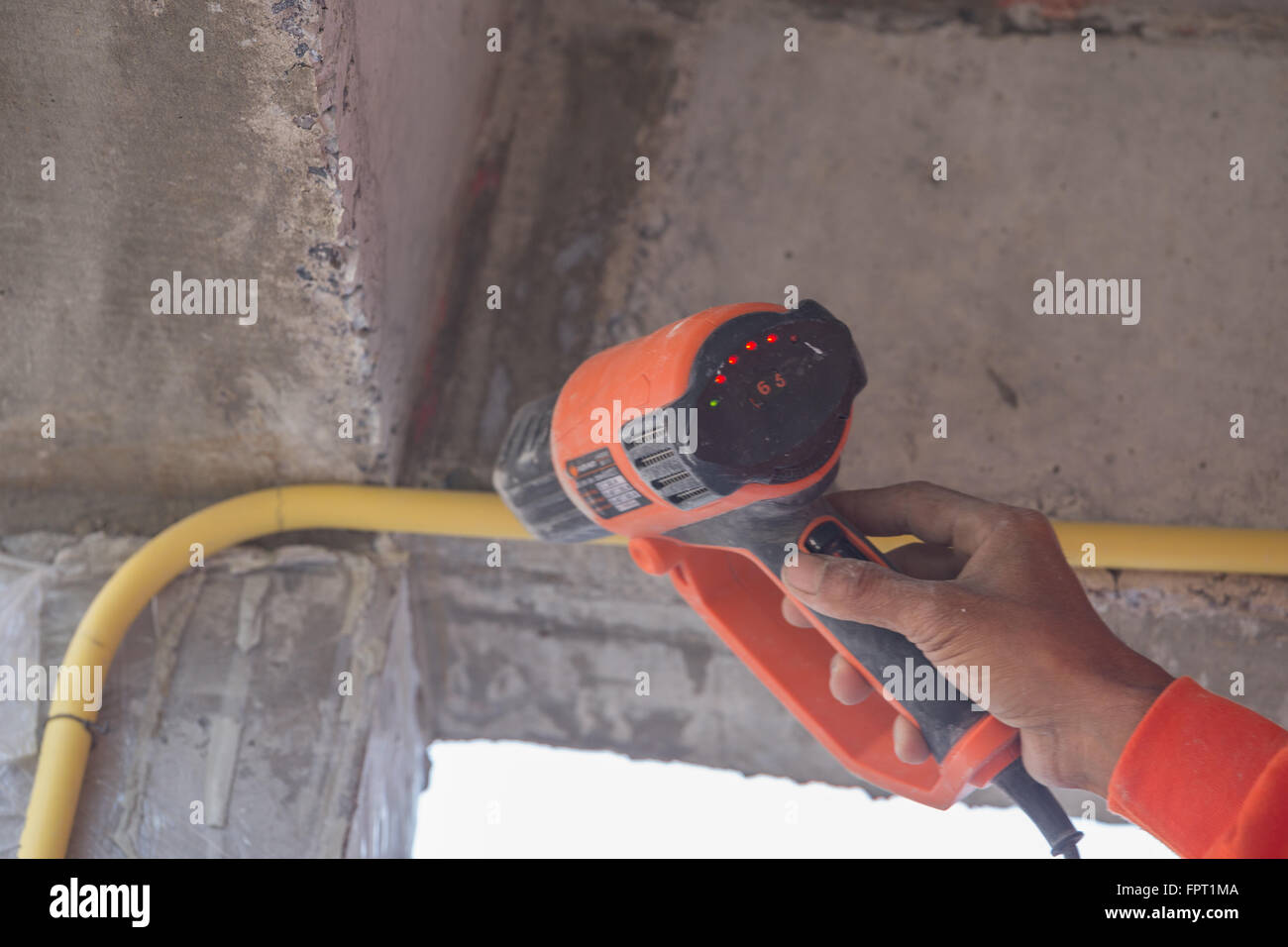 Hand of worker use a heat gun to bending electric PVC pipe Stock Photo