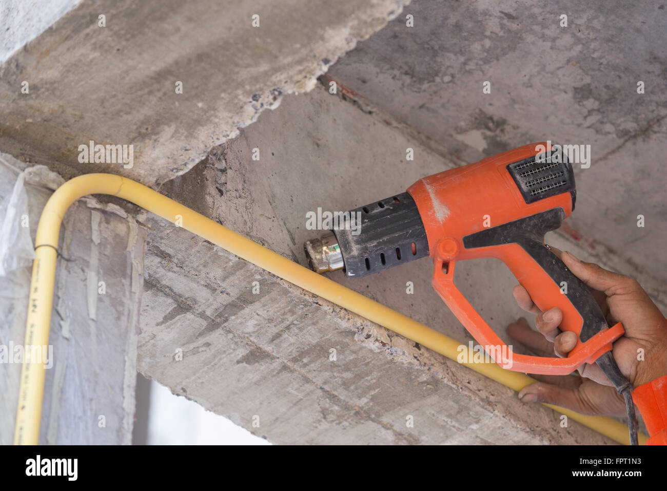 Hand of worker use a heat gun to bending electric PVC pipe Stock Photo
