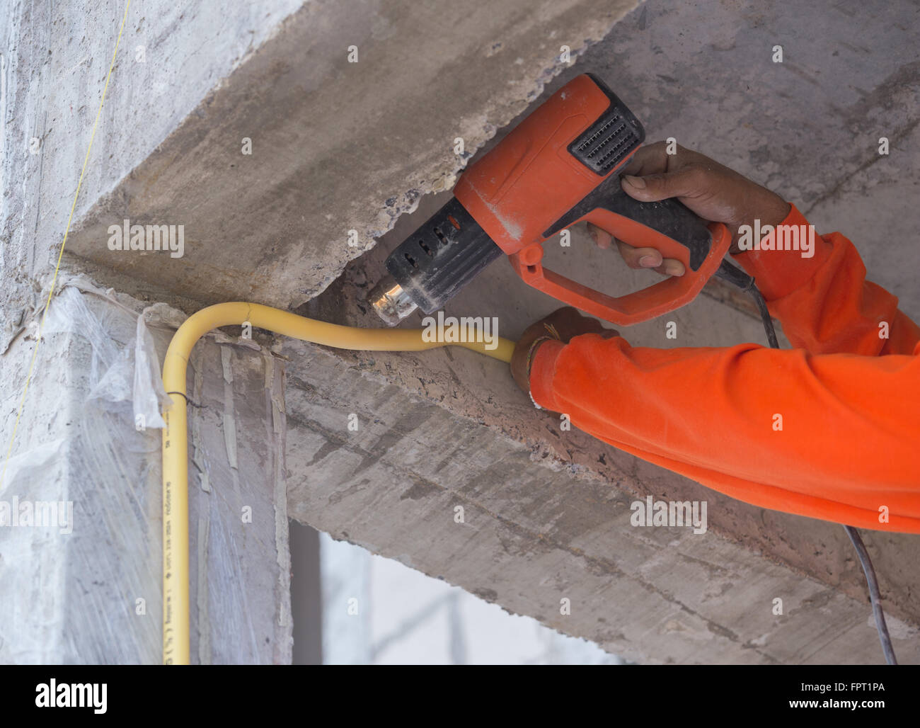 Hand of worker use a heat gun to bending electric PVC pipe Stock Photo