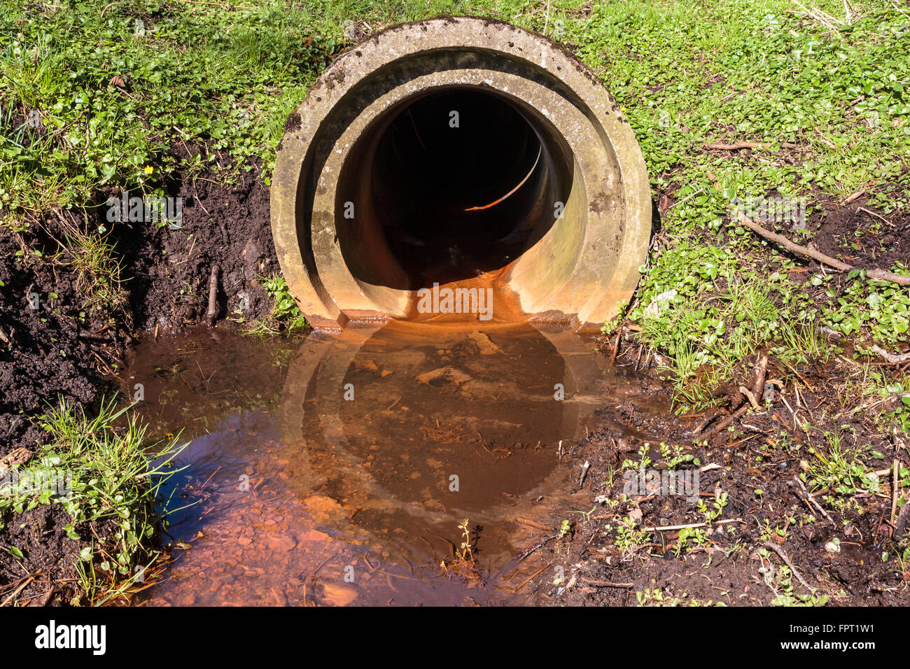 Water running in to a waterstream from a sewer Stock Photo