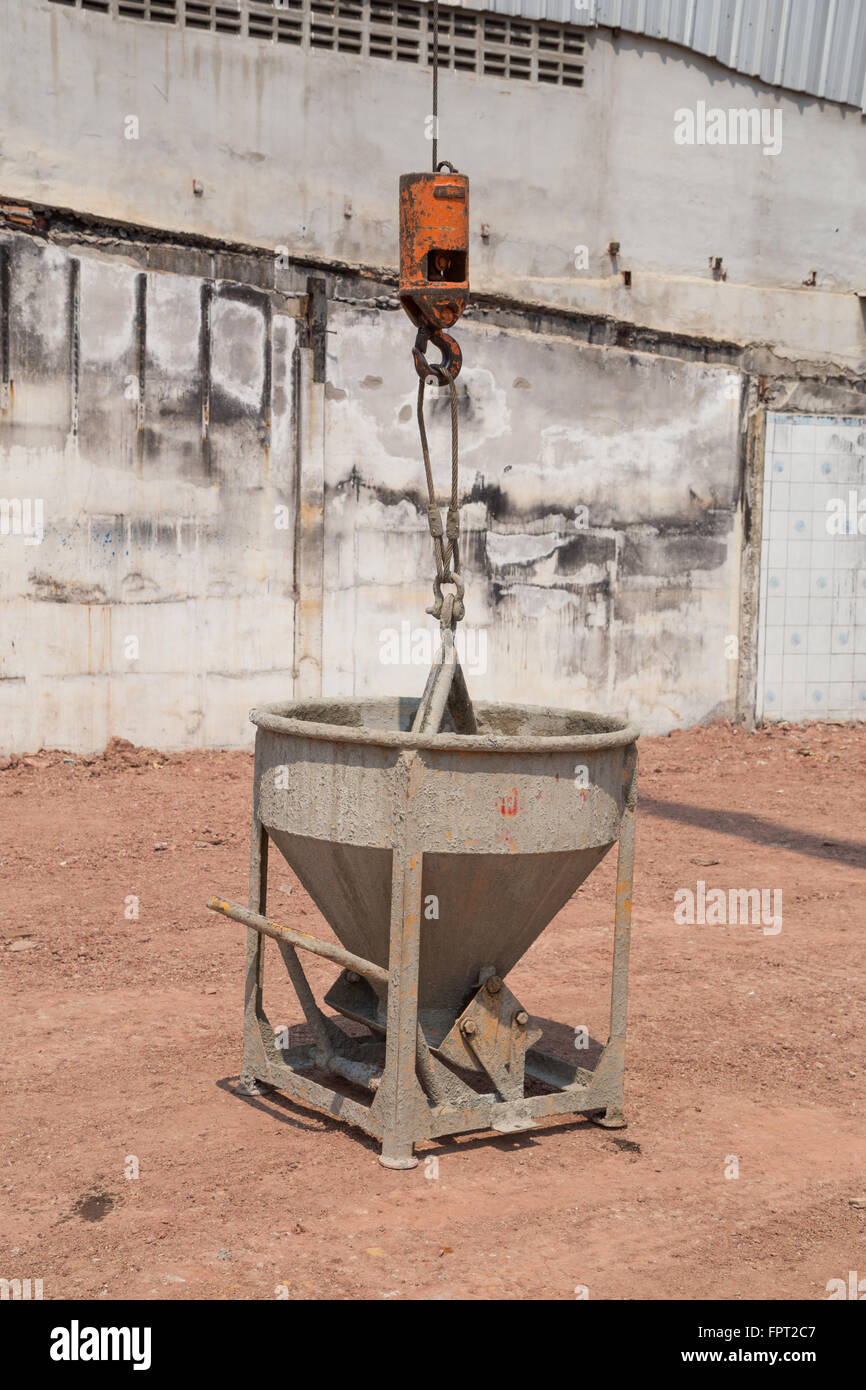 Crane lifting concrete mixer container at construction site Stock Photo