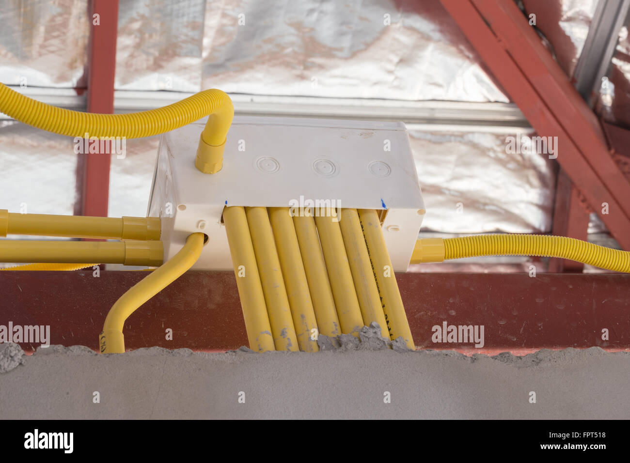 yellow PVC pipes for electrical boxes and wires buried on concrete wall