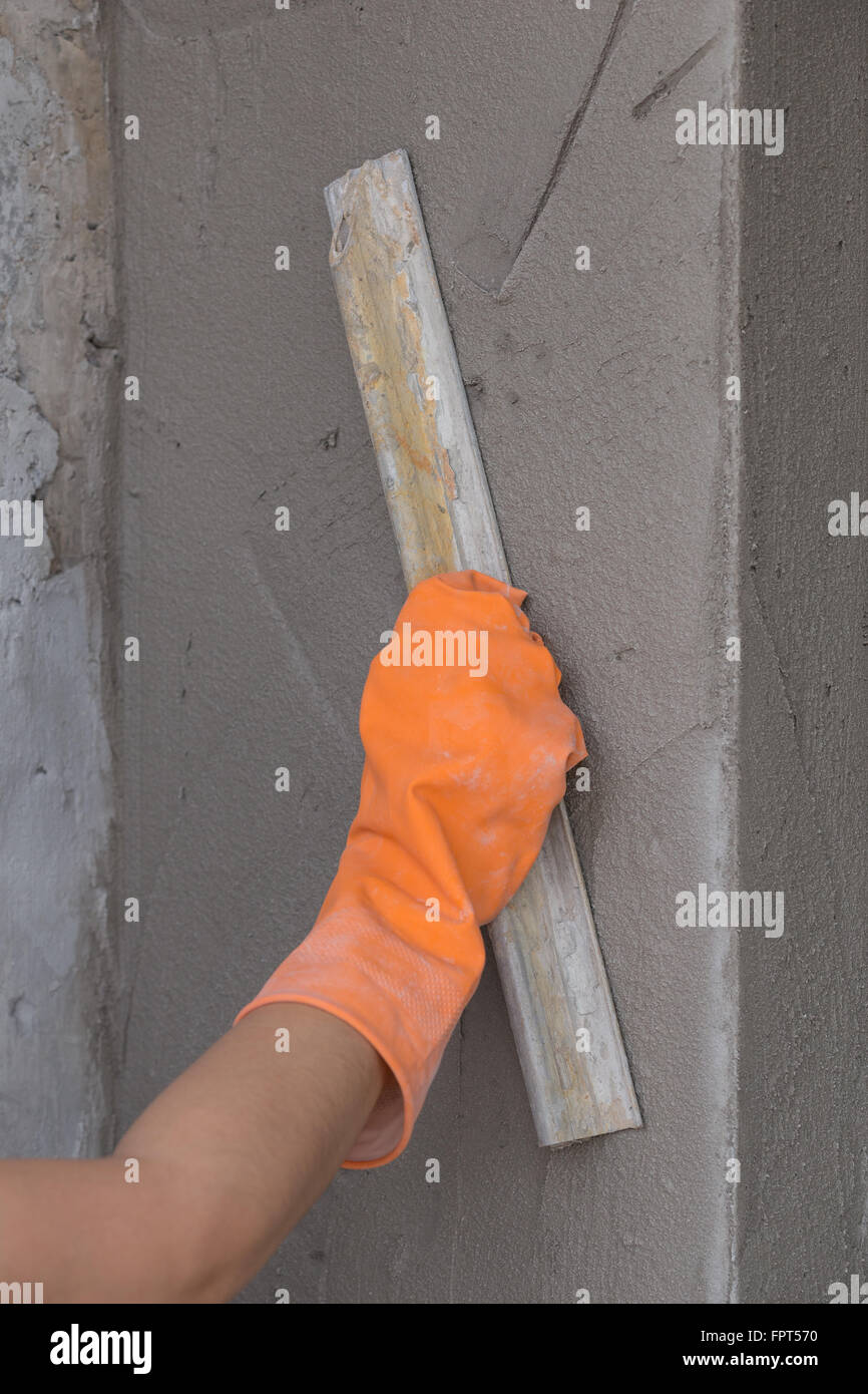 hand of worker use trowel plastering concrete at wall Stock Photo