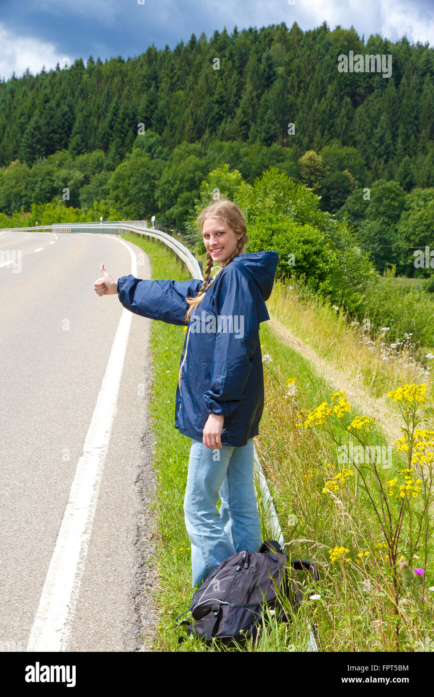 Young woman hitchhiking Stock Photo