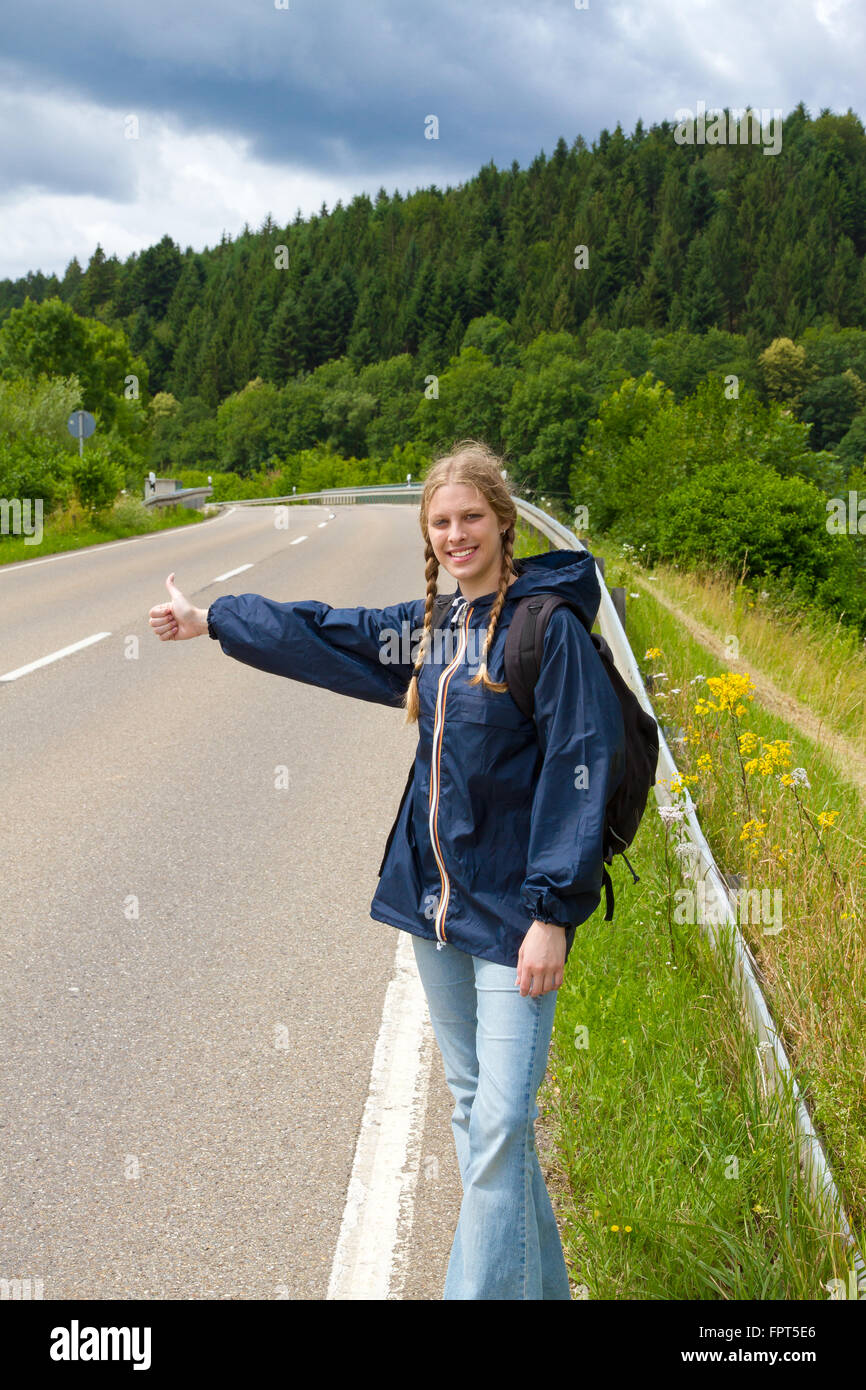 Young woman hitchhiking Stock Photo