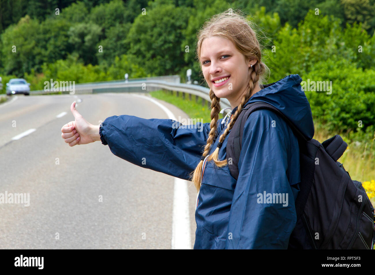 Young woman hitchhiking Stock Photo