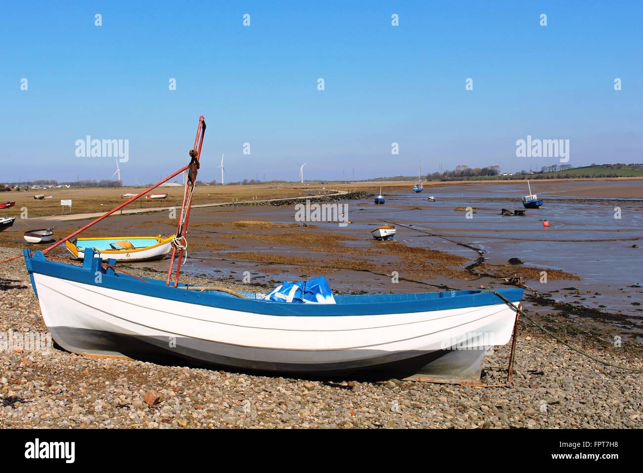 Close up of small boat on shore at Sunderland Point with coastal road