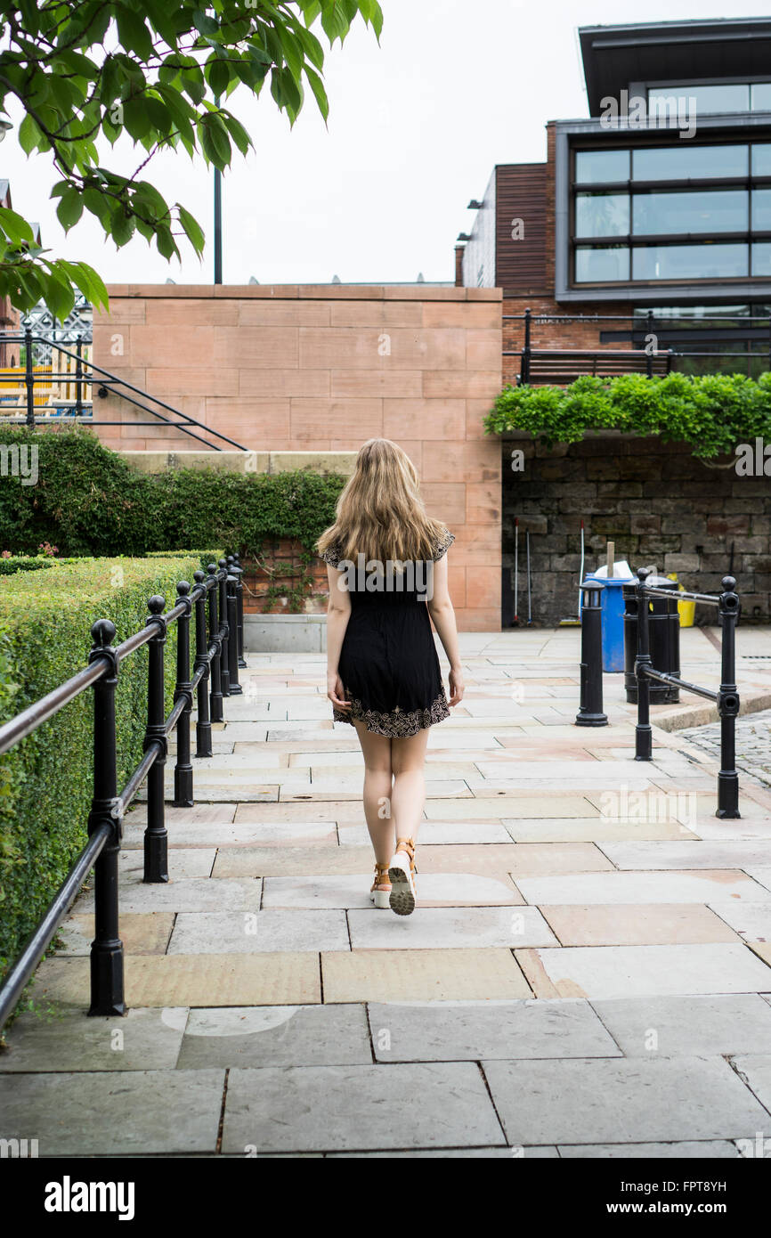 Rear view of a young woman walking in the city Stock Photo - Alamy