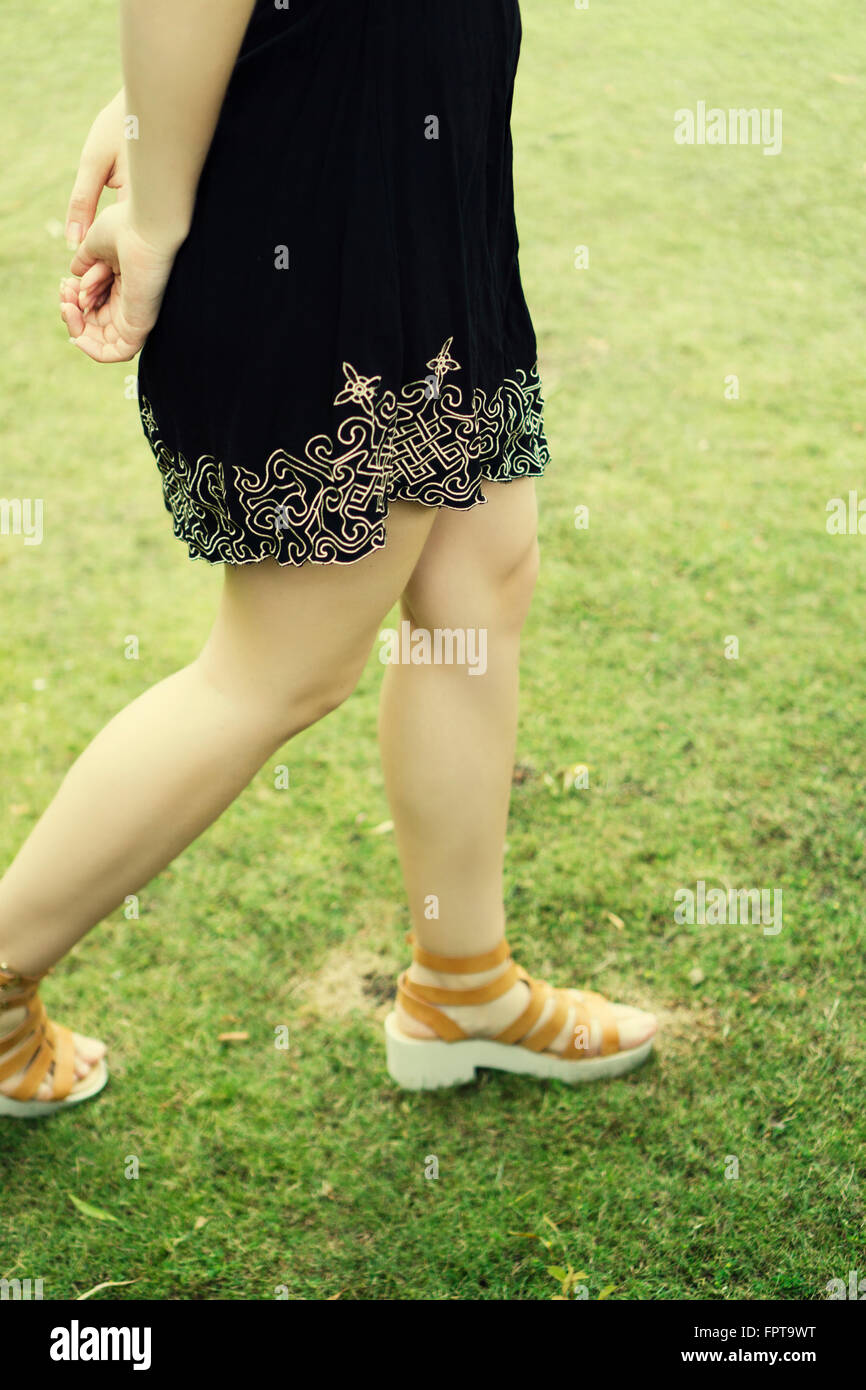 Close up of a young woman walking on the grass Stock Photo
