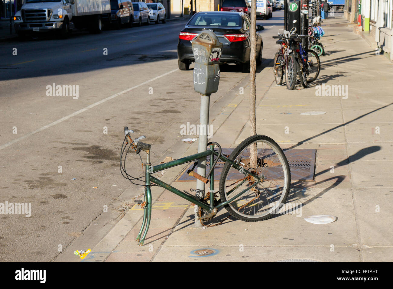 Stripped bicycle locked to parking meter. Pilsen neighborhood, Chicago, Illinois. Stock Photo