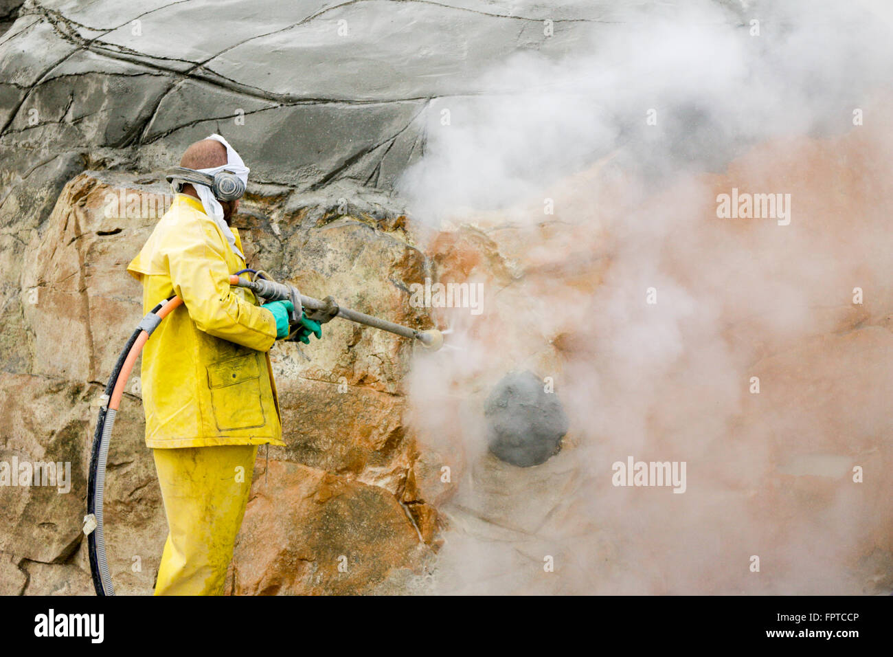 Maintenance worker steam cleaning rocks in seal enclosure. Lincoln Park