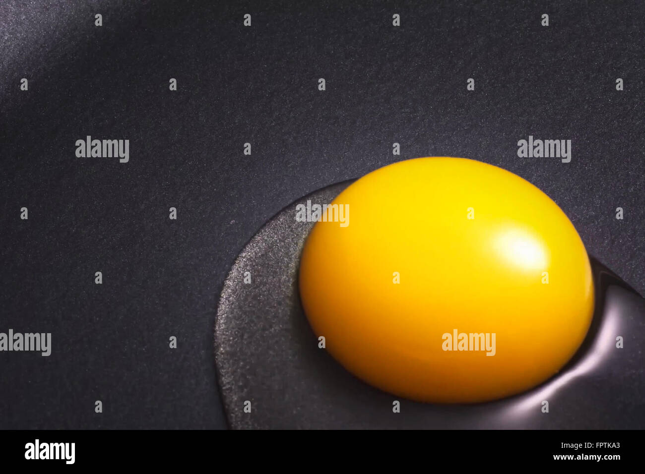 Egg yolk just put in a nonstick skillet. Stock Photo