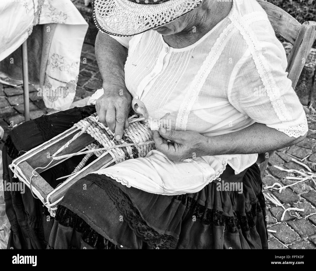 Elderly lady builds bags woven by hand using the dried leaves of the corn cobs. Stock Photo