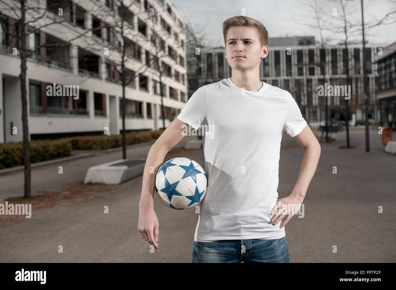 Teenage boy holding football in his underarm, Bavaria, Germany Stock
