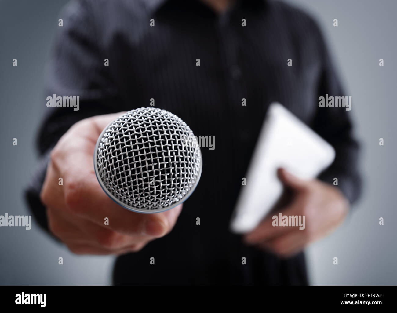 Hand holding a microphone conducting a business interview or press conference Stock Photo