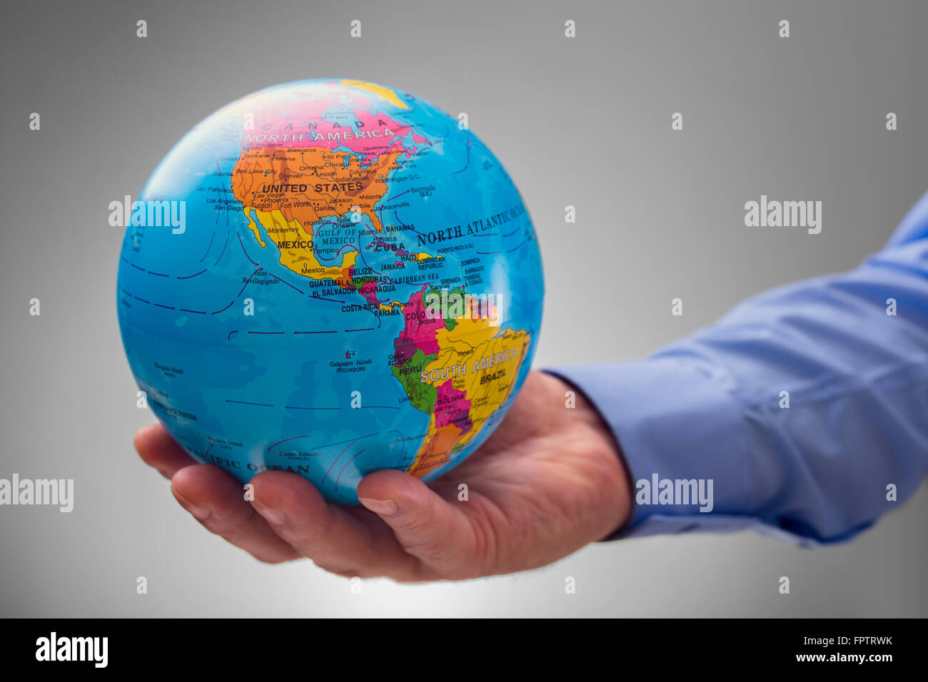 Businessman holding the world in the palm of his hands concept for global business, communications, politics, geography or envir Stock Photo