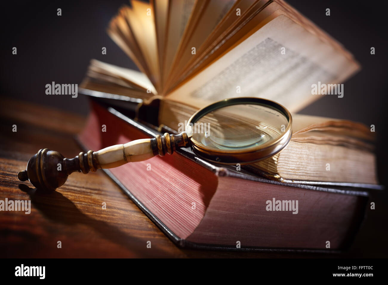 Book and magnifying glass concept for education, knowledge and searching for information Stock Photo