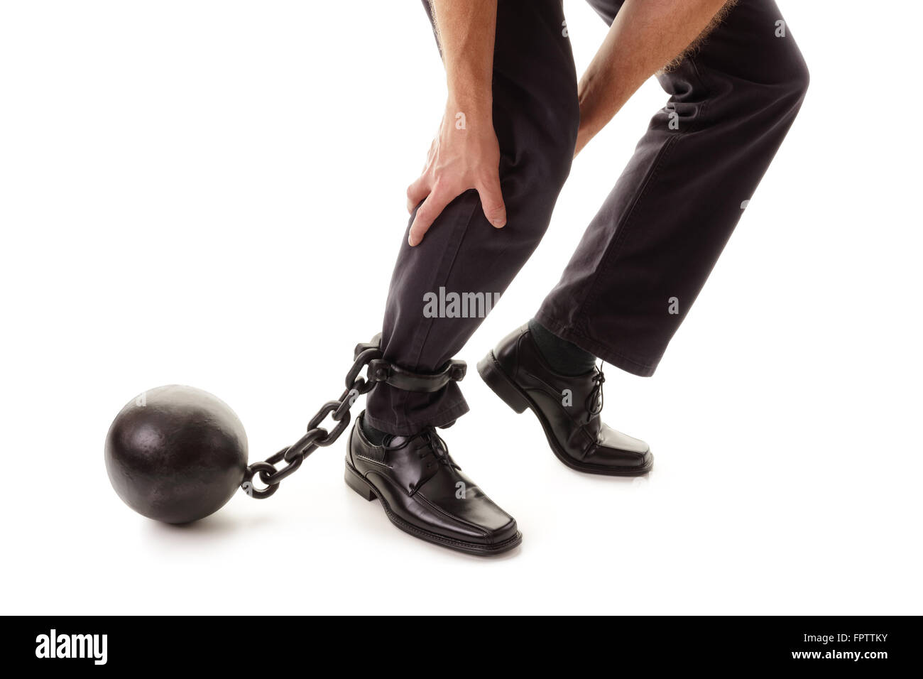 Ball and chain restraining a businessman as he tries to walk concept for business burden, willpower and determination Stock Photo