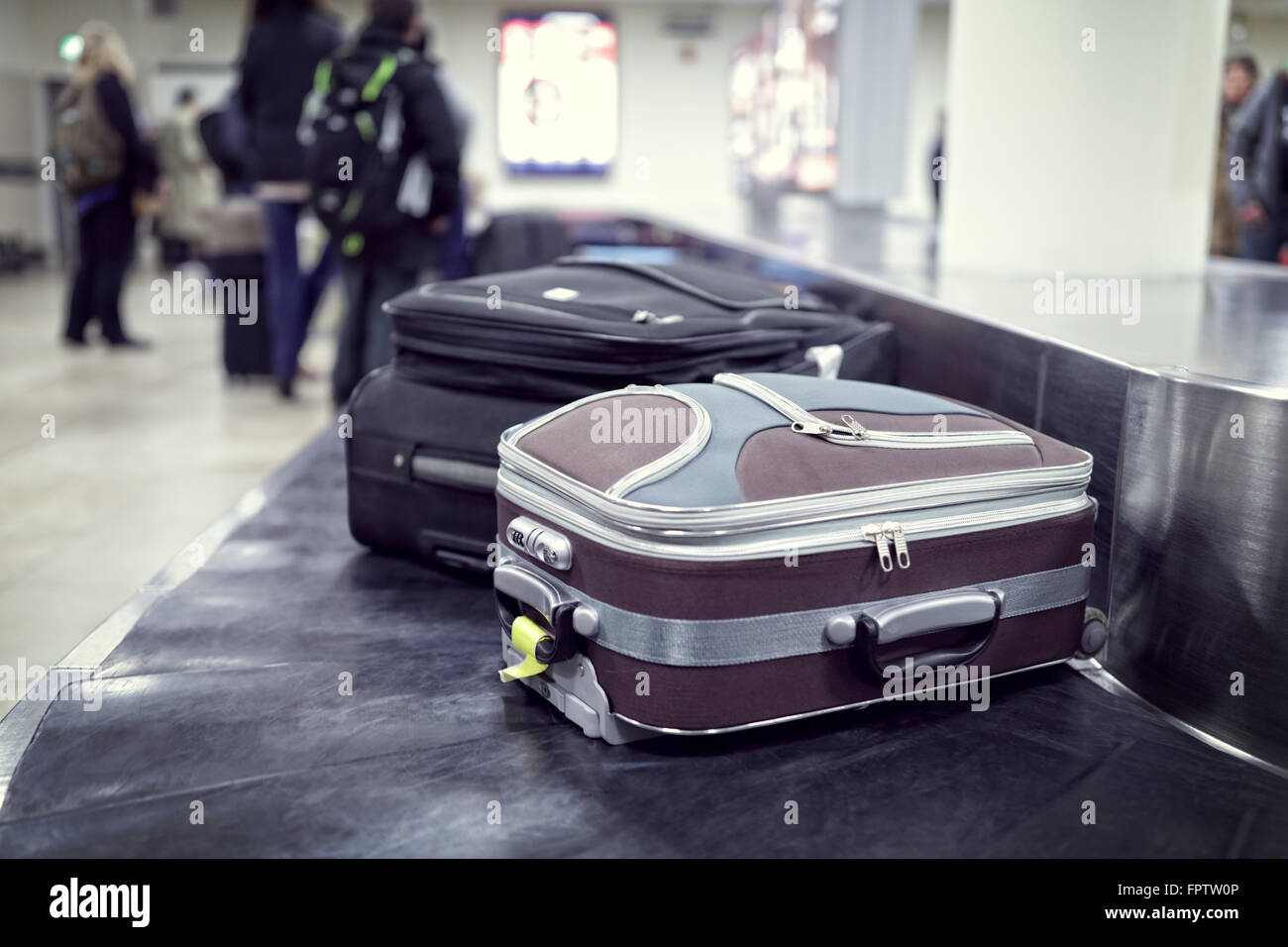 Suitcase on luggage conveyor belt in the baggage claim at airport Stock Photo