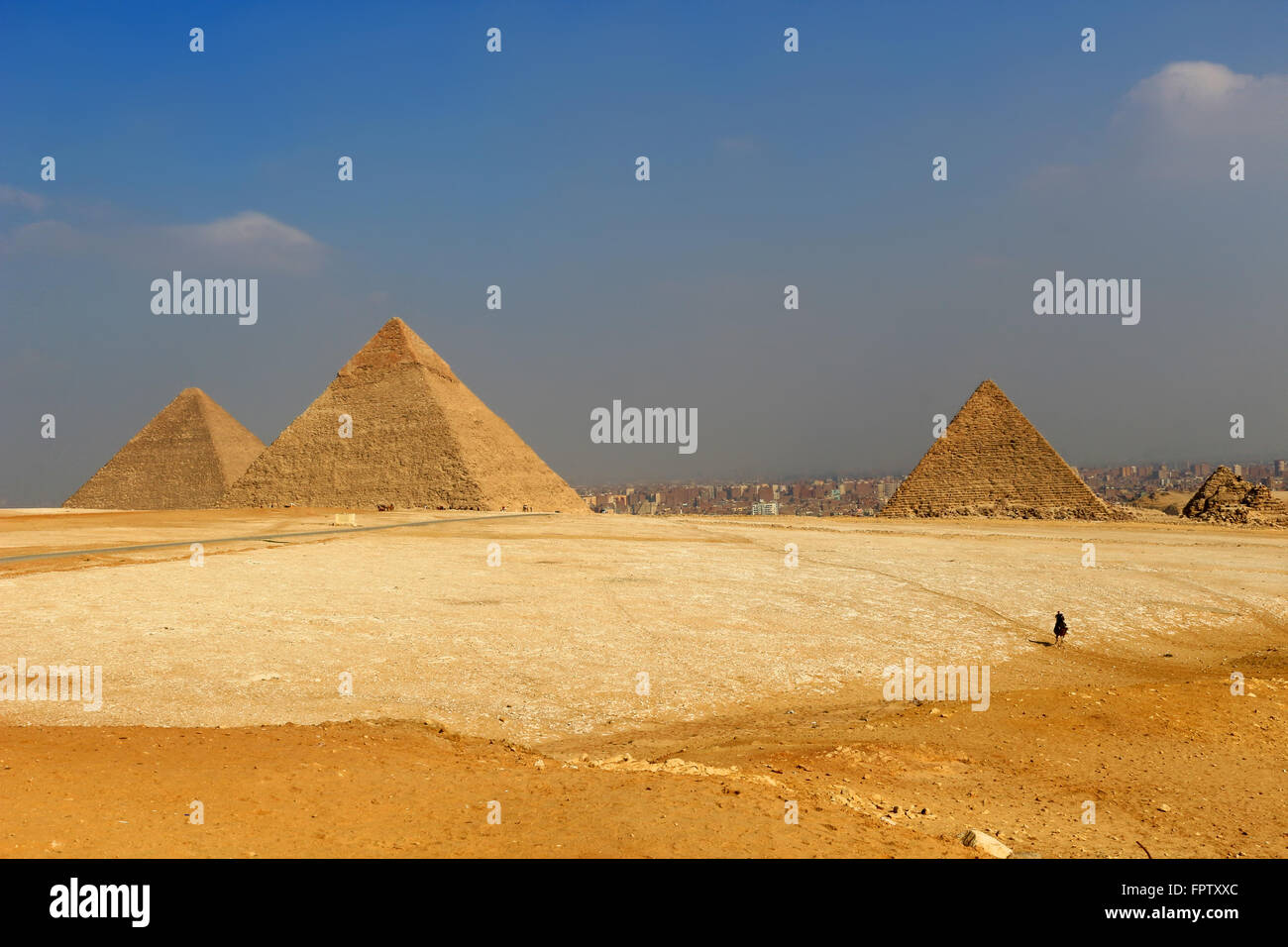 The Pyramids of Giza, man-made structures from Ancient Egypt in the golden sands of the desert with polluted Cairo in the backgr Stock Photo