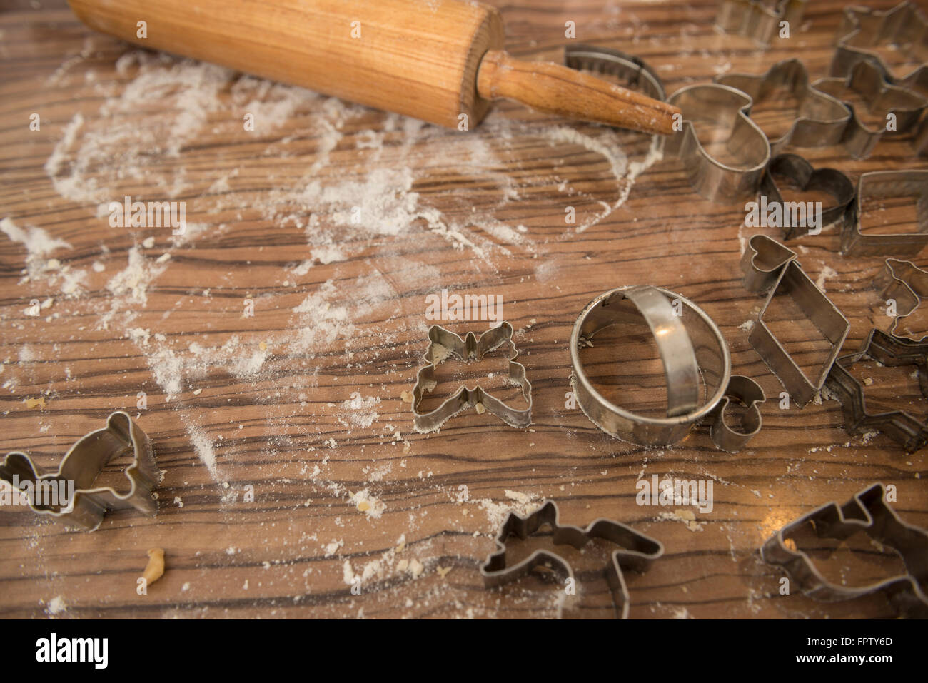 Variety of different cookie cutters with rolling pin on kitchen counter