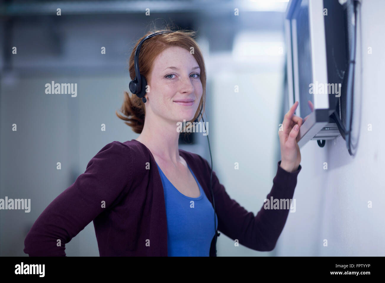 Young female engineer working on touchscreen computer monitor in an