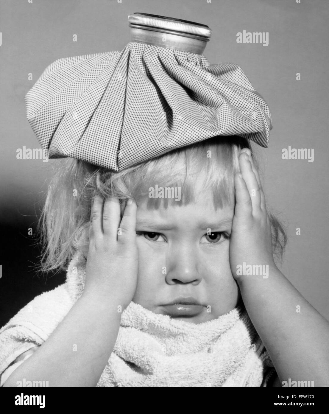 1950s UNHAPPY LITTLE BLONDE GIRL ICE PACK ON HEAD HANDS SIDE OF FACE TOWEL  WRAPPED AROUND NECK FEVER HEADACHE SORE THROAT MUMPS Stock Photo - Alamy