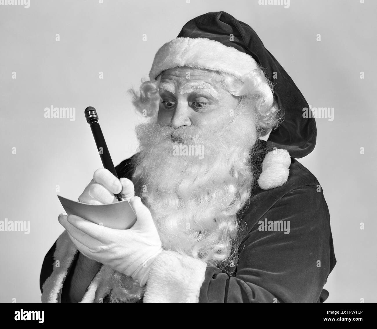 1950s SANTA CLAUS WRITING NAUGHTY AND NICE LIST Stock Photo