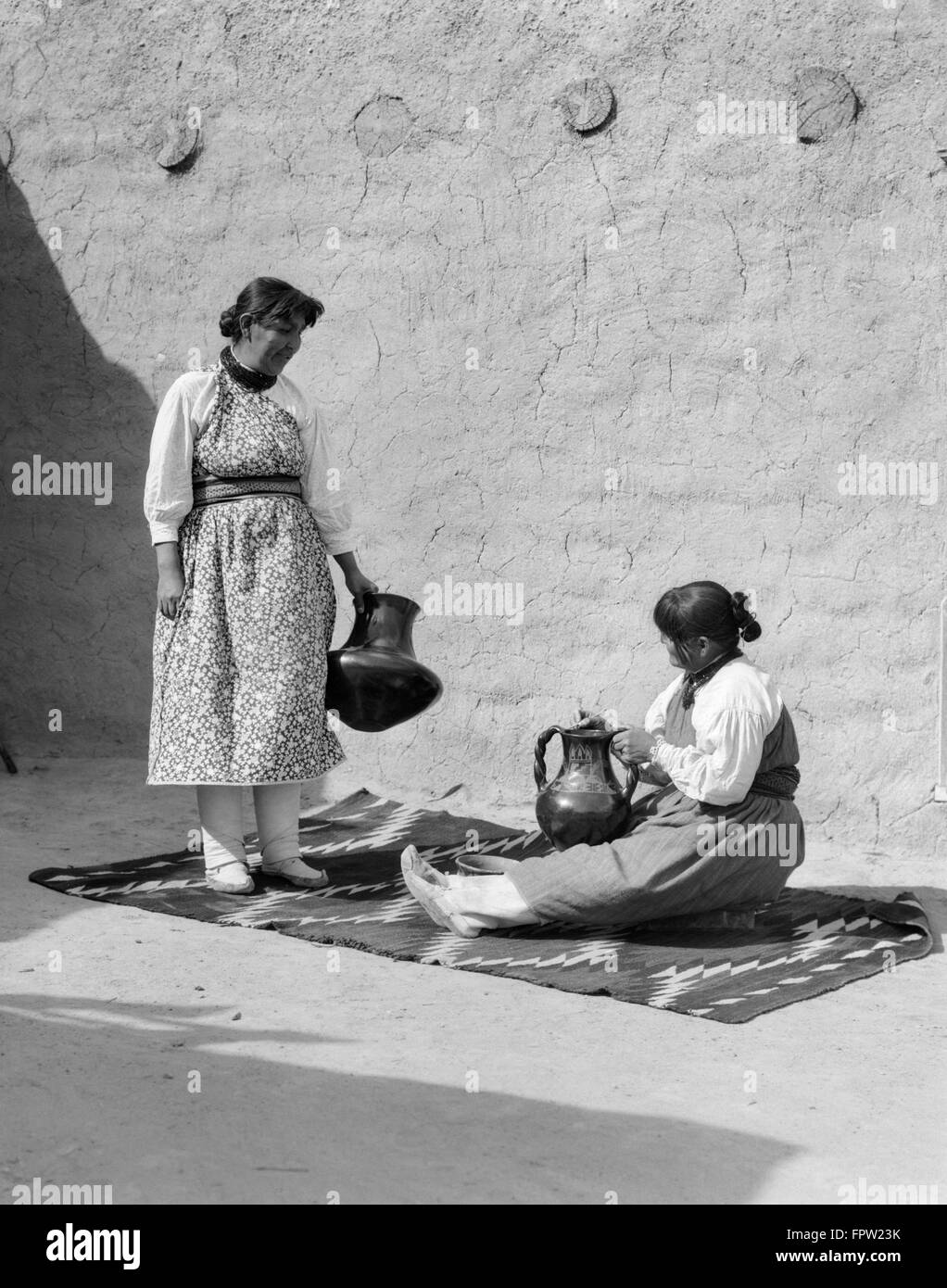 1930s TWO NATIVE AMERICAN INDIAN WOMEN FINISHING POTTERY SANTA CLARA PUEBLO NEW MEXICO USA Stock Photo