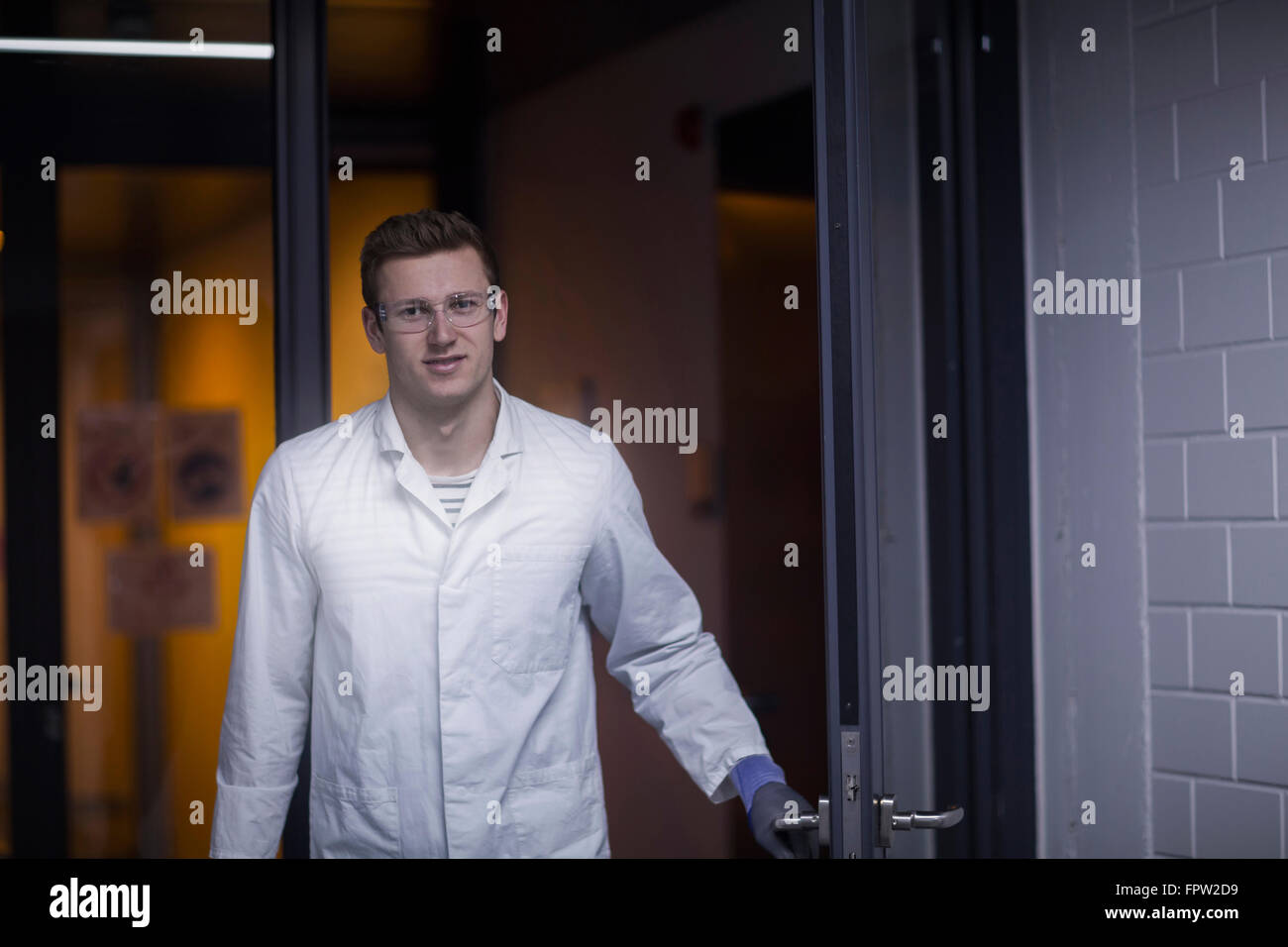 Portrait of a young male scientist working in an optical laboratory