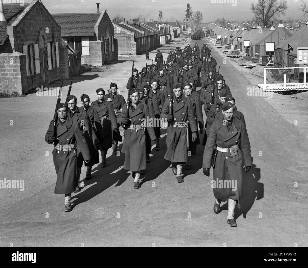 1940s FORT DIX NEW JERSEY TROOPS OF THE 44th DIVISION MARCHING IN CANTONMENT STREET OF FORT DIX NJ Stock Photo