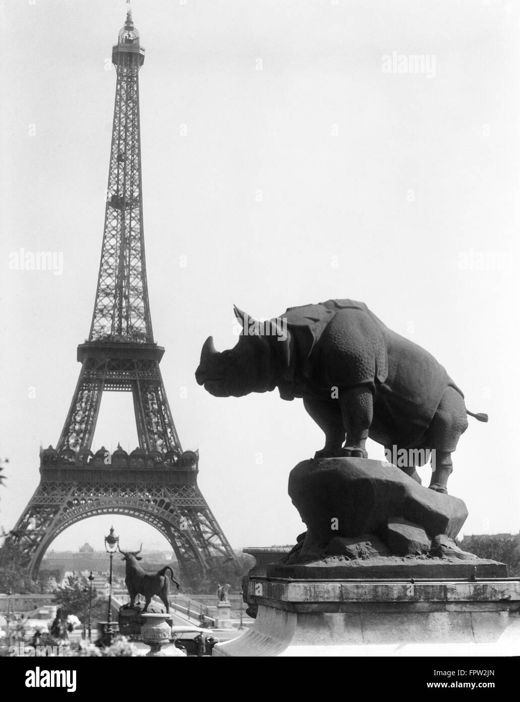1920s RHINOCEROS STATUE IN FOREGROUND EIFFEL TOWER IN BACKGROUND PARIS FRANCE Stock Photo
