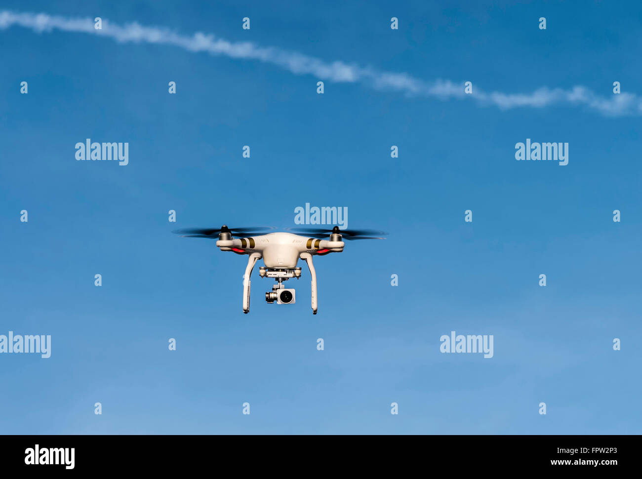 Quadcopter with camera flying in front of a blue sky, Germany Stock Photo