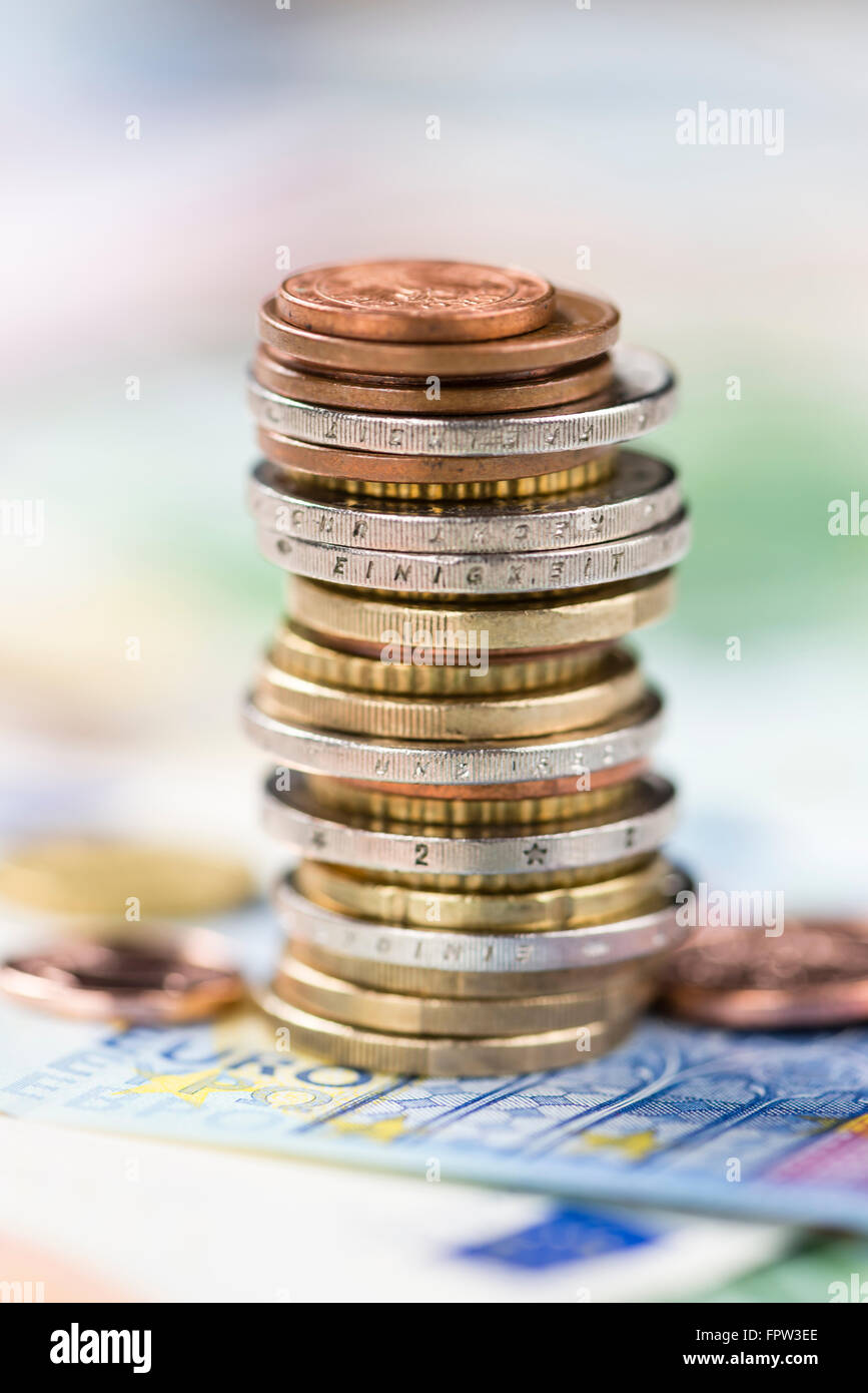 Stacked European Coins on some banknotes (detailed close-up shot) Stock Photo
