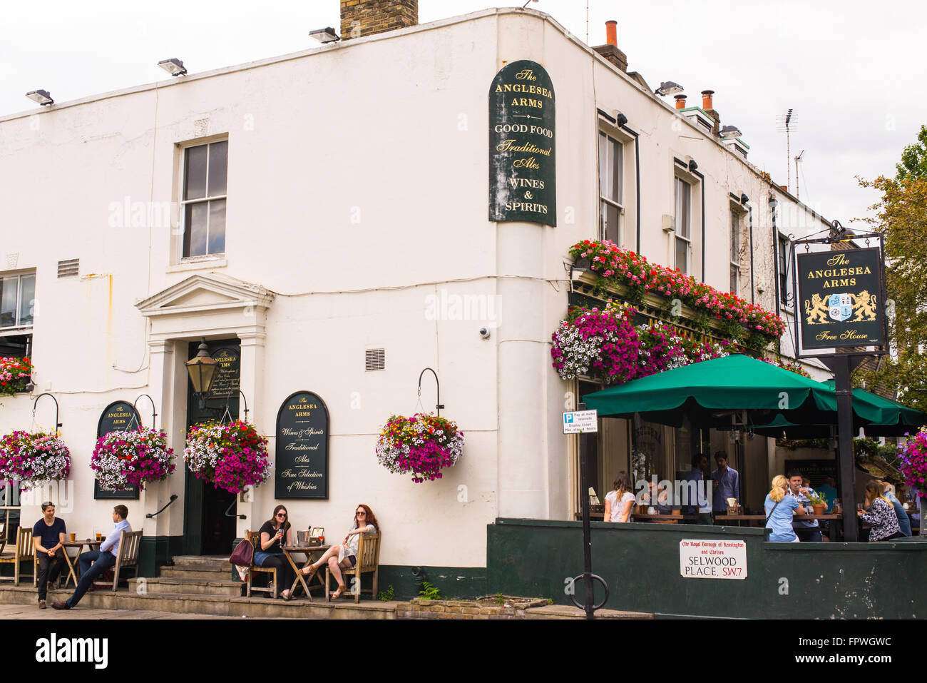 People enjoying the warm weather sitting outside a known pub in Chelsea Stock Photo