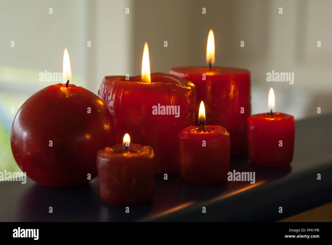 Six red candles burning in low light Stock Photo Alamy