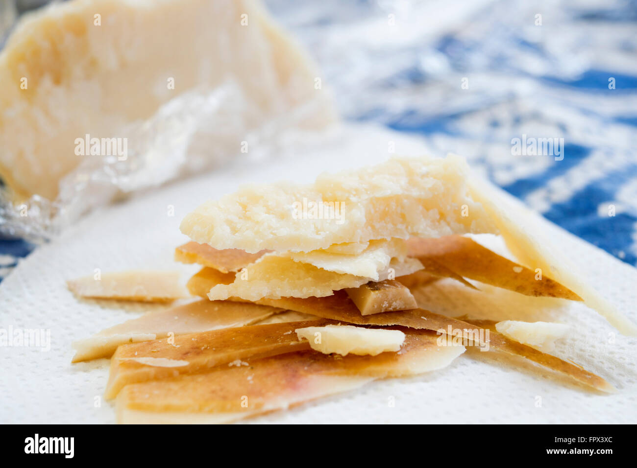 chunks and rind of parmigiano cheese with near a big piece of heart ...