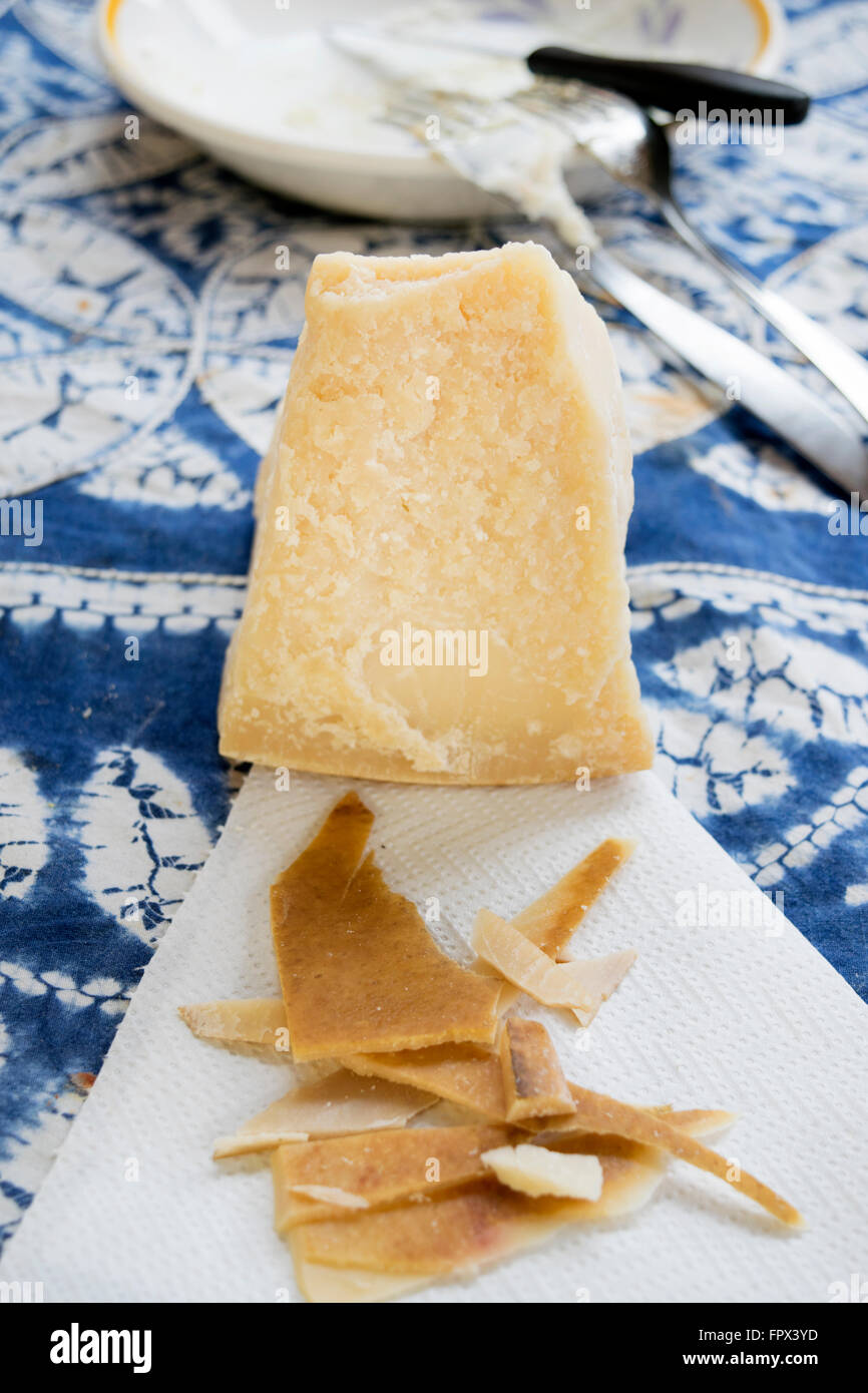 chunks and rind of parmigiano cheese with near a big piece of heart ...