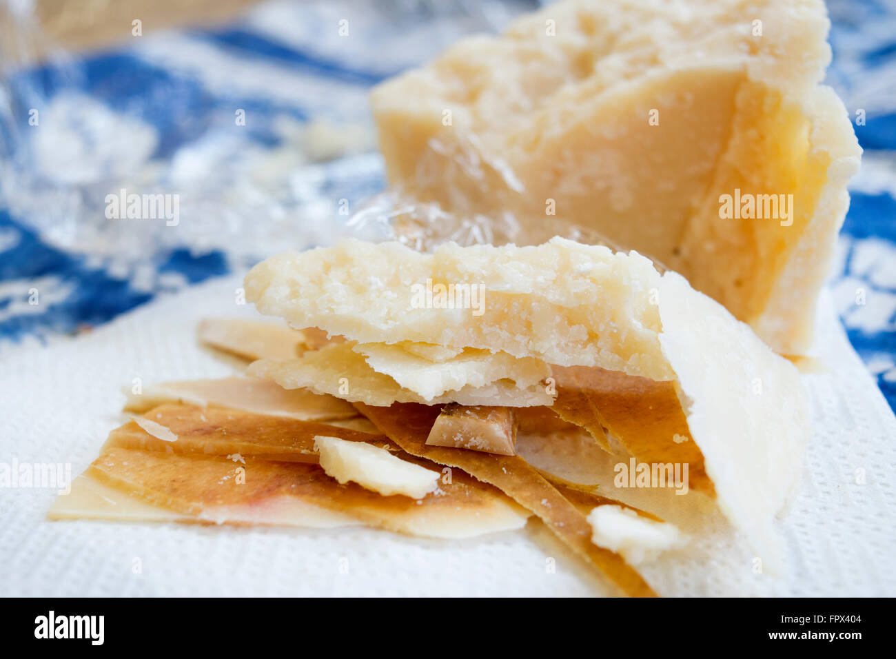 chunks and rind of parmigiano cheese with near a big piece of heart Stock Photo