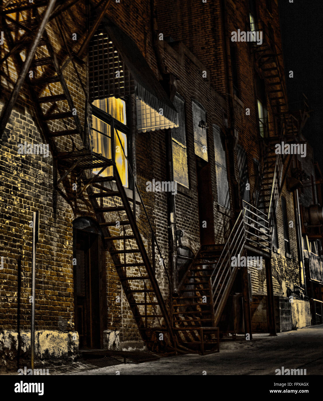 Back street brick lined building alley at night with moonlight Stock Photo