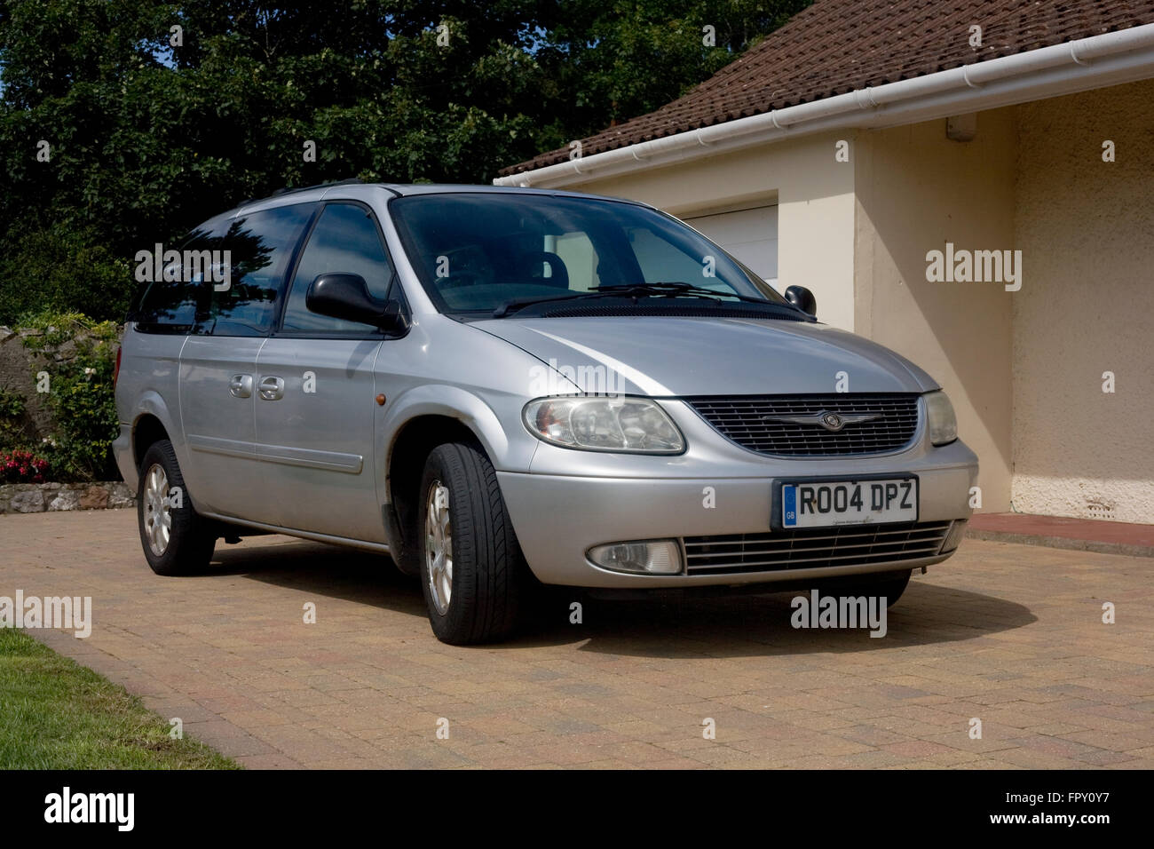 Chrysler grand voyager mpv people carrier parked at owner's home on drive near garage Stock Photo