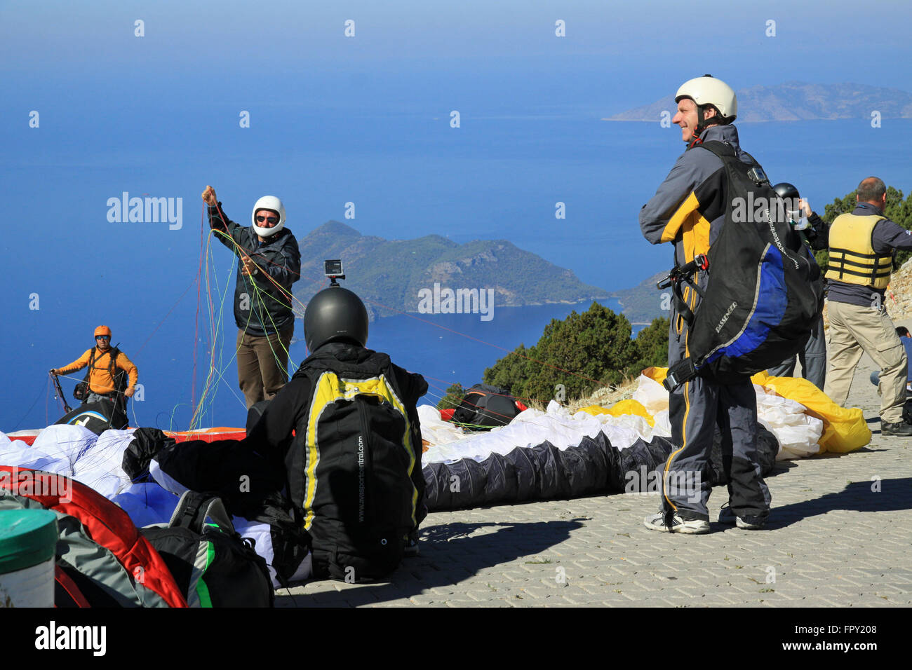 Paragliders paragliding off Babadag mountain to land in Oludeniz near Fethiye Turkey Stock Photo
