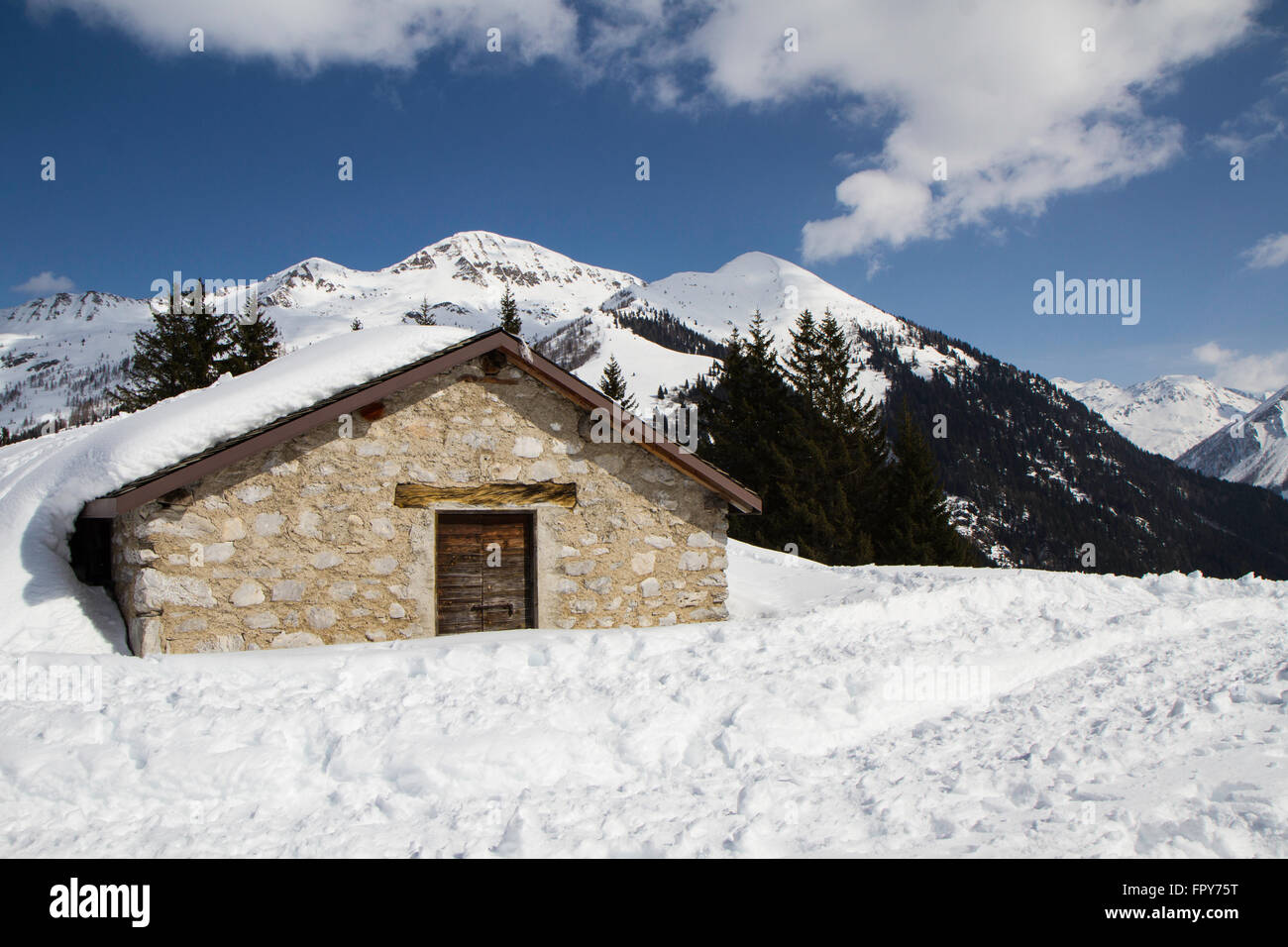 mountain panorama with hut covered in snow, blue sky Stock Photo